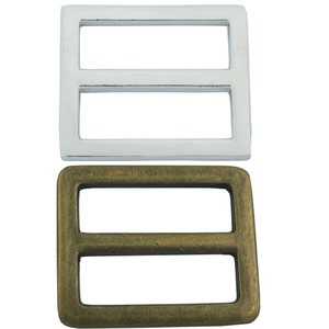 May include: Two metal buckle slides, one silver and one brass. Both are rectangular with two horizontal slots.