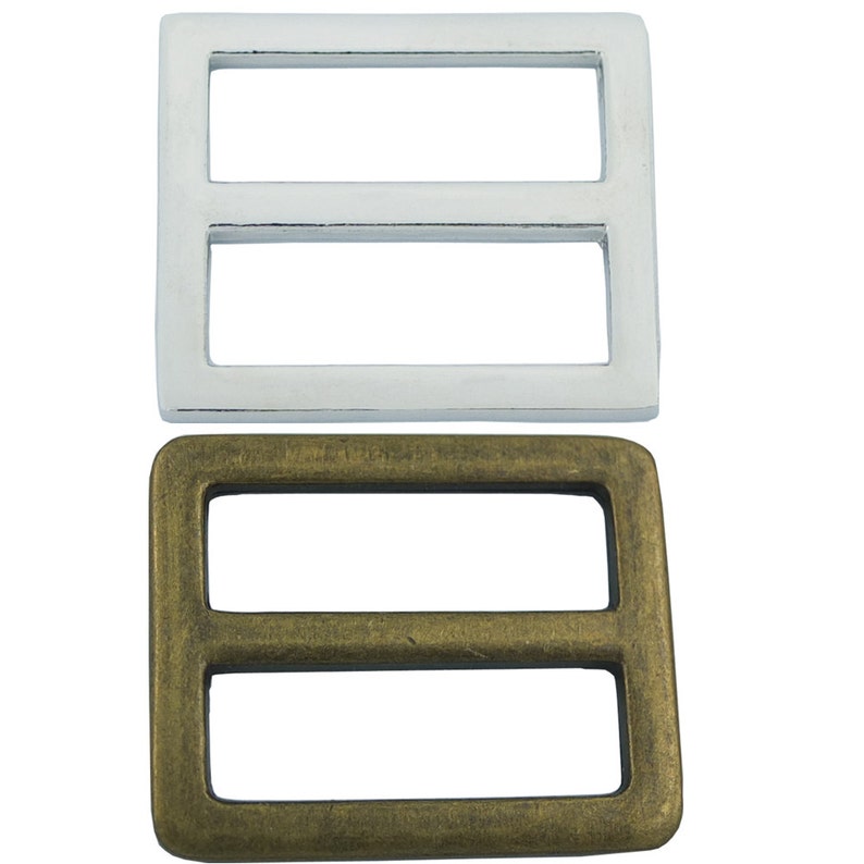 May include: Two metal buckle slides, one silver and one brass. Both are rectangular with two horizontal slots.