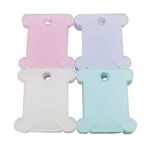 K&ouml;nnte beinhalten: Vier Stapel aus Plastik-Garnrollen in Rosa, Lavendel, Wei&szlig; und Hellblau.