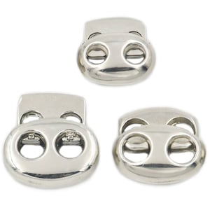 May include: Three silver toggle clasps, also known as cord locks or cord stoppers, in different sizes. These clasps are used to secure cords, drawstrings, or straps.
