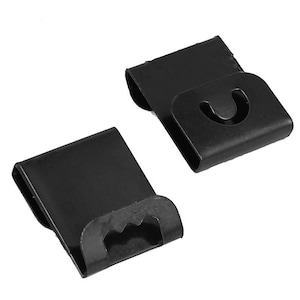 May include: Two black metal hooks with a unique design. The hooks are designed to hang items on a wall or other surface.