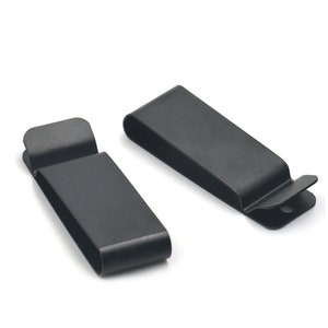 Puede incluir: Dos clips de cinturón de metal negro. Los clips están diseñados para sujetarse a un cinturón y sujetar un cuchillo u otro objeto.