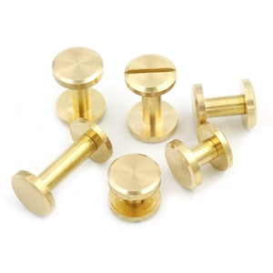 May include: Six gold-toned metal screw-in studs with a round head and a threaded shaft. The studs are arranged in a cluster on a white surface.