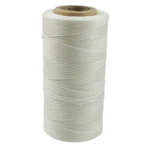 May include: A spool of white waxed thread for leather crafting. The thread is wound tightly on a cardboard spool.
