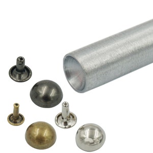 May include: Assortment of metal dome-shaped studs in silver, gold, and black with a silver metal tool for setting the studs.