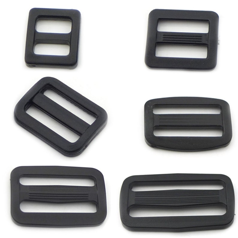 May include: Six black plastic slider buckles of various sizes. The buckles have two parallel slots and are commonly used for straps, bags, and other DIY projects.