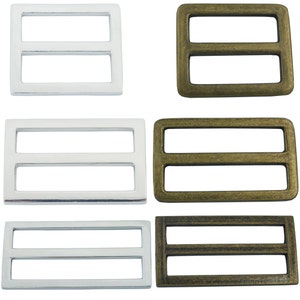 May include: Six metal slider buckles, three silver and three gold. The buckles are rectangular with two horizontal bars.