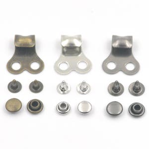 May include: Three sets of metal shoe eyelets and rivets. Each set includes two eyelets, two rivets with prongs, and two flat rivets. The eyelets are available in antique brass, silver, and black.