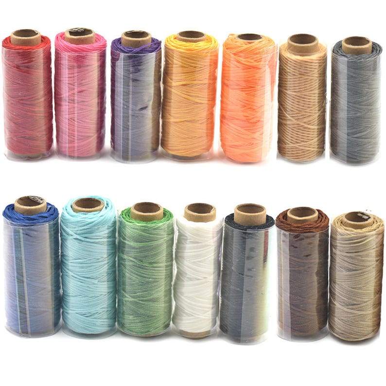 Pu&ograve; includere: Assortimento di 12 bobine di filo cerato in vari colori, tra cui rosso, rosa, viola, arancione, giallo, marrone, blu, verde, bianco, nero e beige. Le bobine sono disposte in due file da sei.