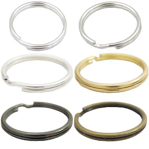 Könnte beinhalten: Sechs Schlüsselringe in verschiedenen Ausführungen: Silber, Gold, Antik-Silber und Antik-Messing. Jeder Ring ist doppelt geschlungen und hat eine geteilte Ringöffnung.