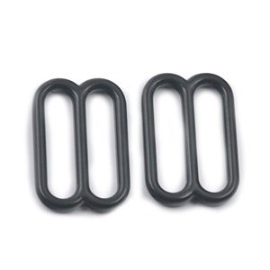 May include: Two black metal slider buckles. The buckles are designed to be used for adjusting the length of straps or belts.