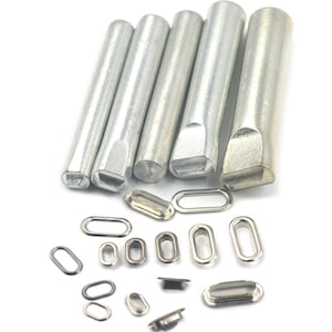 May include: Set of six metal grommet punches and a variety of silver oval grommets in different sizes.