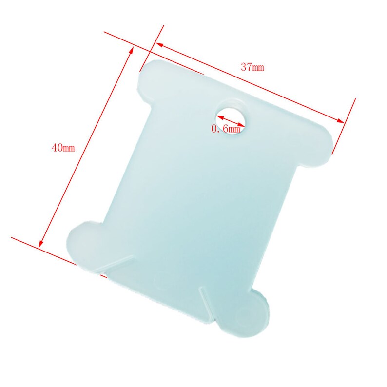 K&ouml;nnte beinhalten: Eine wei&szlig;e Plastik-Garnrolle mit einem 0,6 mm Loch in der Mitte. Die Rolle misst 37 mm x 40 mm.