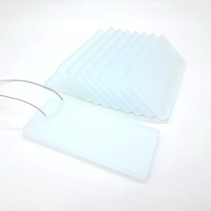 May include: A set of rectangular, semi-transparent frosted acrylic tags with rounded corners. Each tag features a pre-drilled hole at one end, and a thin, flexible silver-toned metal wire loop is attached to the front-most tag for hanging.