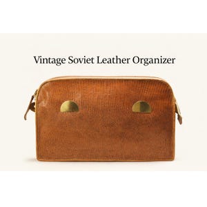 May include: A vintage brown leather organizer with a textured surface and two gold-colored metal accents. The rectangular bag has a zipper closure and small handles on each side. The text "Vintage Soviet Leather Organizer" is above the bag.