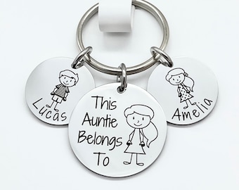 May include: A silver keychain with three round tags. The center tag has the text "This Auntie Belongs To" and a stick figure drawing of a girl. The other two tags have stick figure drawings of a boy and a girl and the names "Lucas" and "Amelia" respectively.