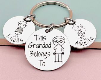 May include: Silver keyring with three round tags. The centre tag has the text "This Grandad Belongs To" and a cartoon drawing of a man with glasses. The other two tags have cartoon drawings of children and the names "Lucas" and "Amelia".