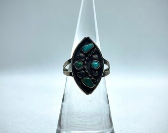 May include: A silver ring with a turquoise stone set in a leaf-shaped design.
