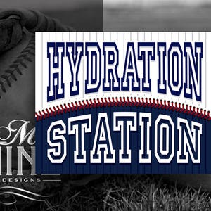May include: A white and blue baseball-themed sign with red stitching. The sign reads "HYDRATION STATION" in a bold, white font.
