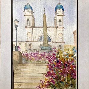 May include: Watercolor painting of a European church with two blue-domed towers and a central obelisk. A staircase leads up to the church, with colorful flowers in the foreground. A black lamp post is on the left.