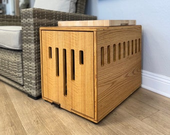 May include: A wooden dog crate with a removable top that can be used as a side table. The crate has a light wood finish and is made of solid wood. The crate is sitting on a light wood floor.