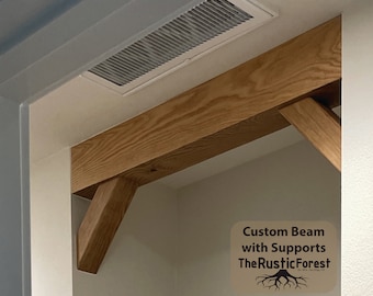 Op de afbeelding: Een op maat gemaakte houten balk met steunen, gemaakt door The Rustic Forest. De balk is in een lichte bruine kleur gebeitst en heeft een natuurlijke houtnerf. De steunen zijn ook van hout en zijn schuin aan de balk bevestigd.