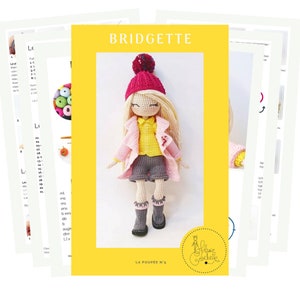 May include: Crochet doll pattern for a girl named Bridgette. The pattern includes instructions for making a pink coat, yellow shirt, grey shorts, and grey boots. The doll is wearing a red hat with a white pom-pom.
