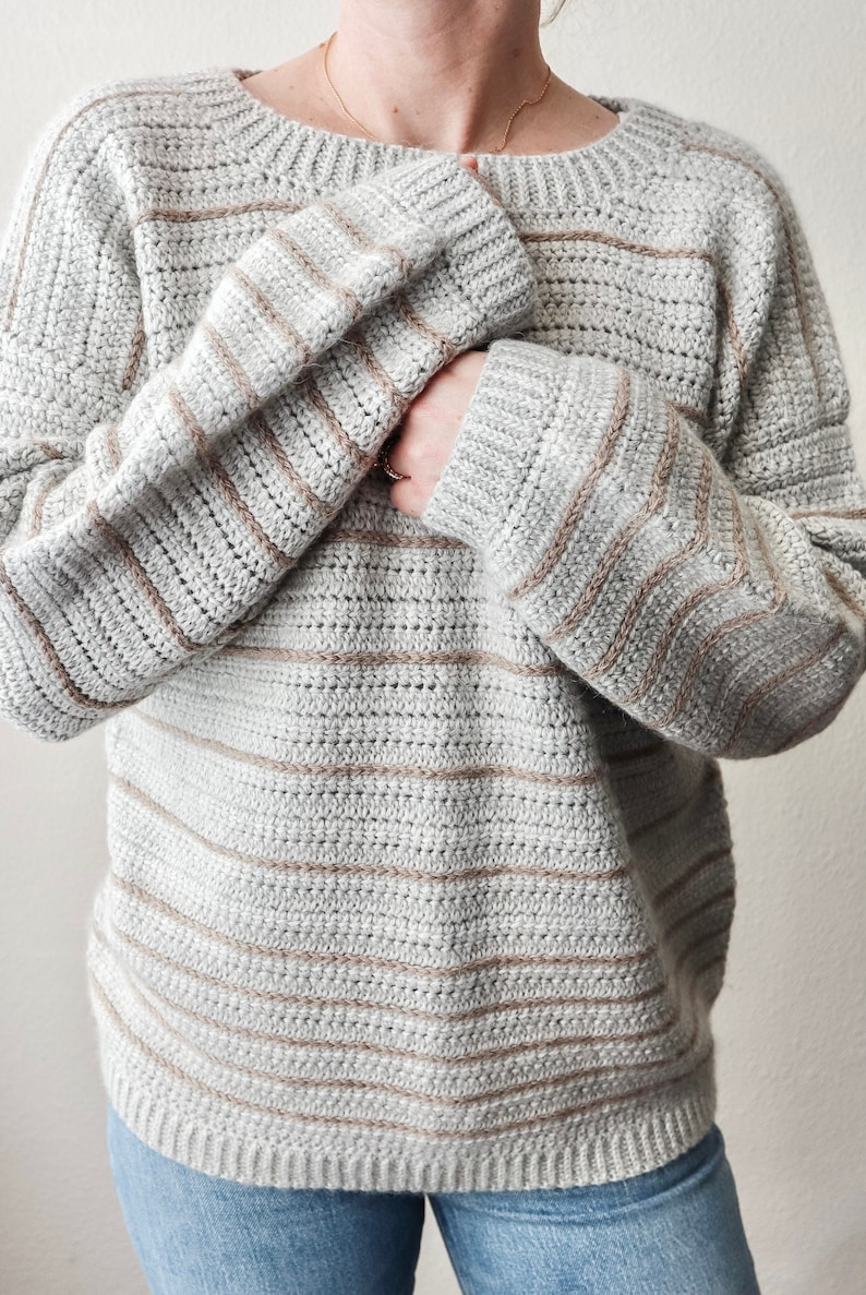 May include: A grey and brown striped crocheted sweater with a relaxed fit.