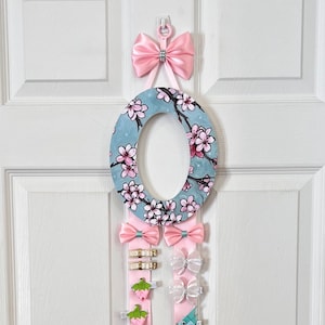 Organizador de lazos para el pelo con flores de cerezo personalizadas en rosa y azul, soporte para lazos de niña, letra de pared, letra inicial