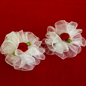 Juego de pinzas con flores blancas y centro rojo