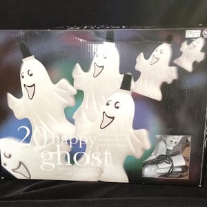 May include: A box of 20 white ghost shaped lights with the text "20 happy ghost" on the front. The ghosts are lit up and have a black outline.