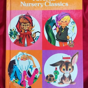 May include: A vintage children's book titled "The Rand McNally Book of Favorite Nursery Classics." The cover features four colorful illustrations of storybook characters, including Little Red Riding Hood and a bunny with a turtle.