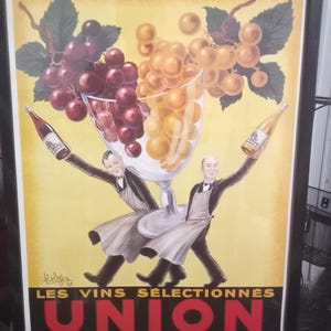 May include: Vintage framed poster with a wine theme. The artwork features two figures holding wine bottles, a large wine glass filled with grapes, and the text "UNION" in red. The background is yellow with grape vines.