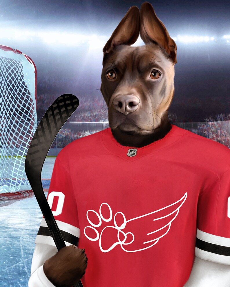 May include: A brown dog wearing a red hockey jersey with a white paw print and wing design. The dog is holding a black hockey stick.