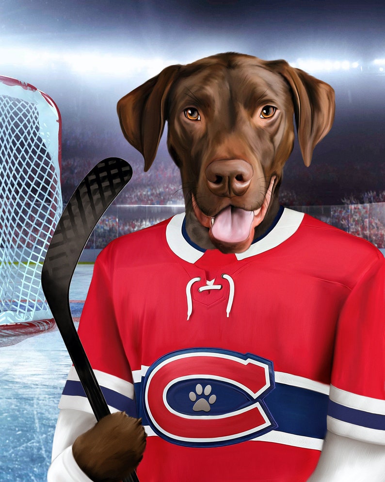 May include: A brown dog wearing a red, white and blue hockey jersey with a paw print on the "C". The dog is holding a black hockey stick.