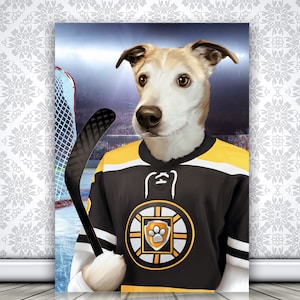May include: A white and brown dog wearing a black and yellow hockey jersey with a paw print logo. The dog is holding a hockey stick and is standing in front of a hockey net.