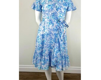 May include: A knee-length wrap dress featuring a vibrant blue and white floral pattern. The garment includes short flutter sleeves, a V-neckline, a side tie closure at the waist, and a ruffled hemline that adds texture to the overall silhouette.