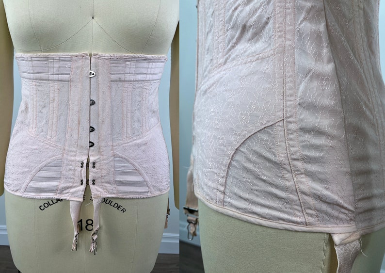 May include: A pale pink corset with a lace pattern and a hook and eye closure in the back. The corset has a boned structure and garter straps at the bottom. The words "COLLAR" and "SHOULDER" are written on the bottom of the corset.