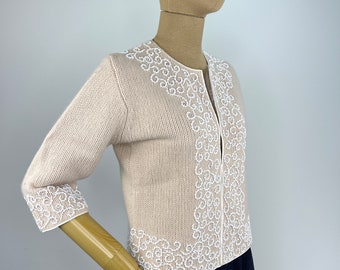 Cárdigan beige vintage de los años 60 con adornos de cuentas blancas con diseño de volutas. Marshall Field & Company