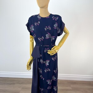 Abito vintage in rayon blu navy, anni '40, con stampa a fiocco rosa e grigio, drappeggio sui fianchi in taffetà e cintura rivestita in tessuto abbinato.