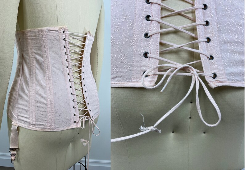 May include: A pale pink corset with a lace-up back and a floral pattern. The corset has a hook and eye closure at the front and is made of a soft, lightweight fabric.