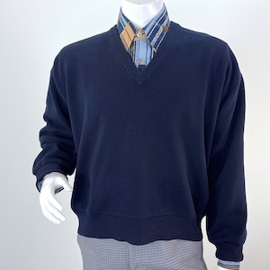 Puede incluir: Un suéter azul marino de cuello en V con mangas largas y dobladillo de canalé.