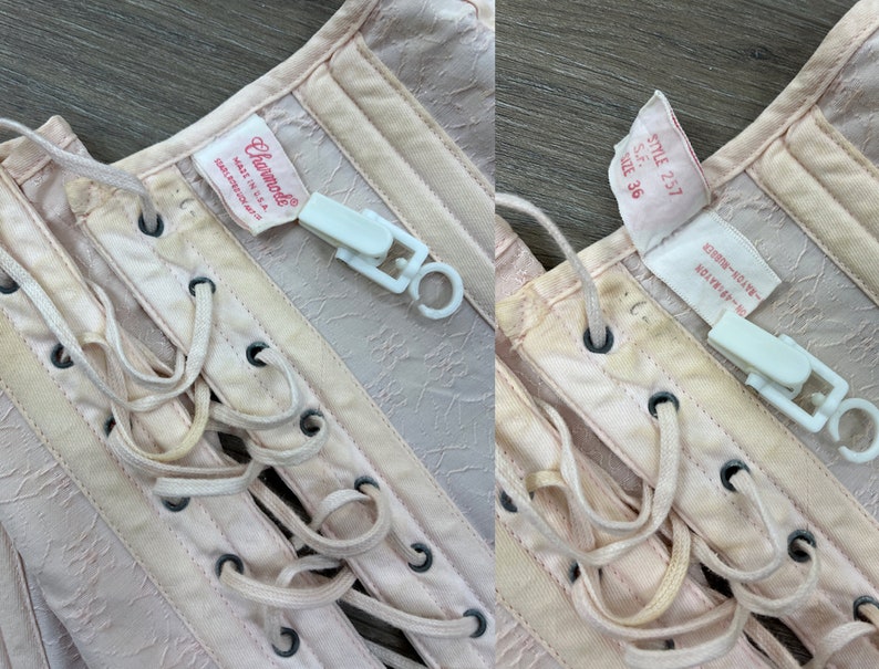May include: A pink satin corset with white lace-up detailing. The corset has a label that reads "Charmode Made in U.S.A." and another label that reads "Style 257 S.F. Size 36 Rayon Rayon-E."