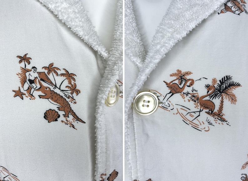 May include: White terry cloth robe with a tropical print featuring palm trees, a surfer, and an alligator. The robe has a shawl collar and large, round buttons.