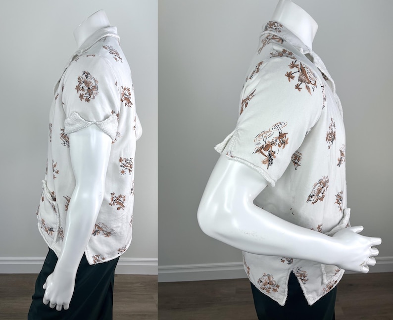 May include: White button-down shirt with short sleeves, featuring a repeating brown floral and bird pattern. The shirt is displayed on a mannequin, showcasing its design and fit. The shirt has a classic collar and buttoned front.