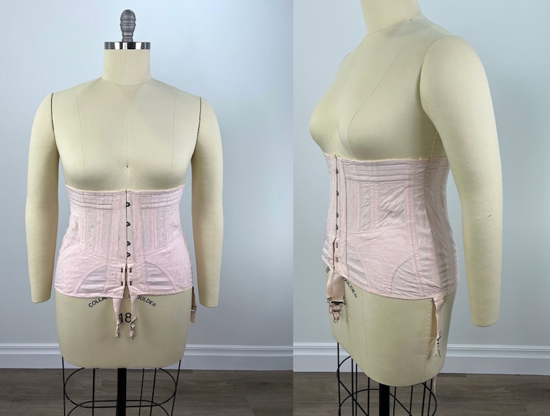 May include: A pink corset with a front closure and adjustable straps. The corset has a boned structure and is designed to cinch the waist.