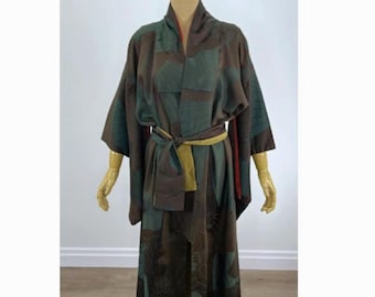 Puede incluir: Una bata tipo kimono de manga larga con una paleta de colores marrón oscuro y verde azulado apagado con un patrón de abanicos repetido. La prenda incluye un fajín verde oliva liso atado a la cintura y un forro rojo en el cuello.