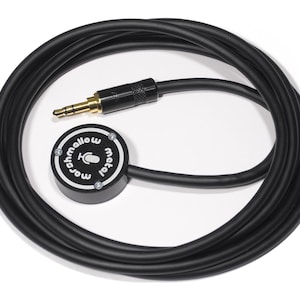 May include: A black audio microphone with a 3.5mm jack and a coiled cable. The microphone has a circular body with the text "marshmallow metal" and a microphone icon. The jack has a gold-colored tip.