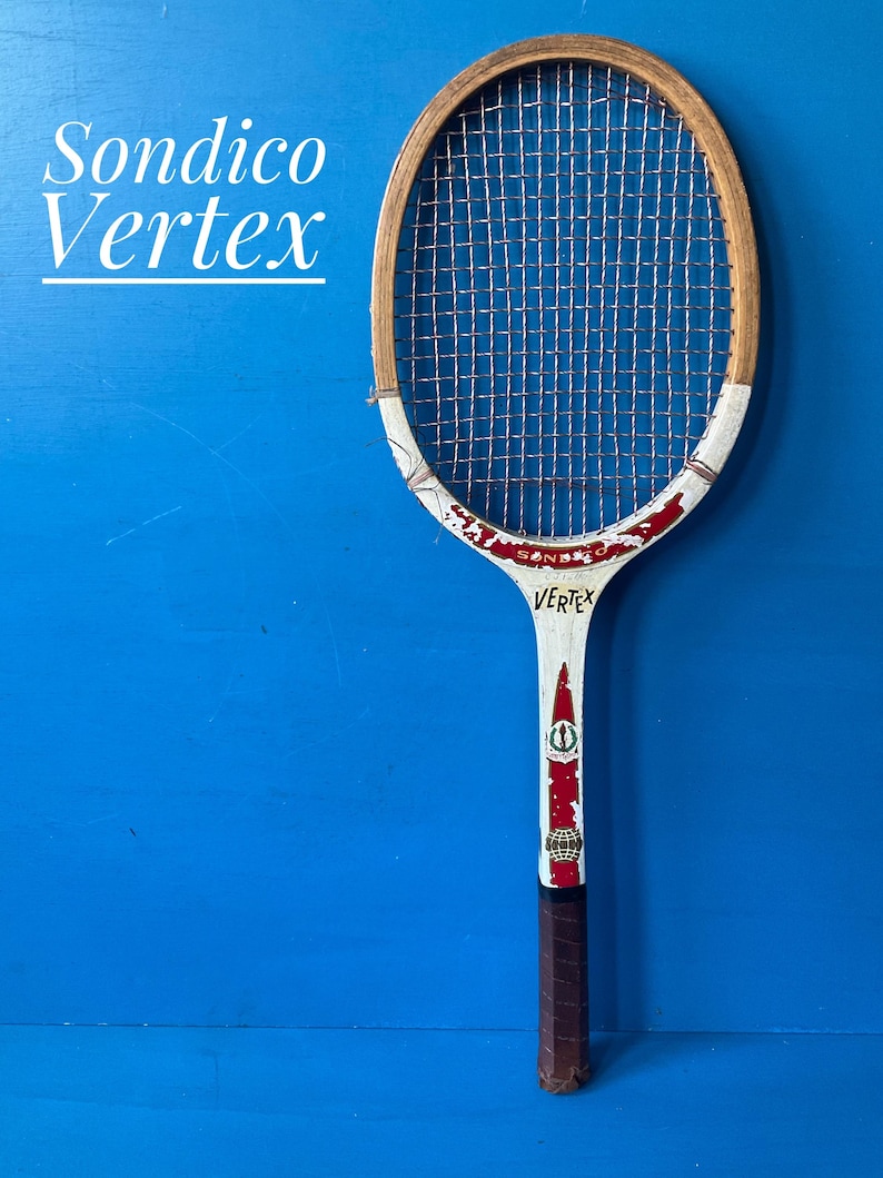 A vintage wooden tennis racket with a natural wood frame, white throat, and red accents. The racket features the text Sondico Vertex, a grid of strings, and a brown leather-wrapped handle. The design includes small circular logos.