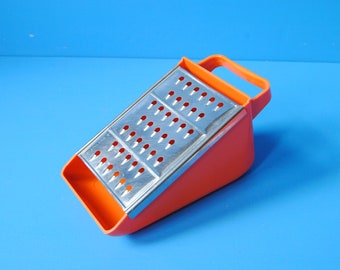Vintage 1970’s orange plastic Pyrex Triplicut grater with interchangeable removable stainless steel blades. Vintage kitchen appliance
